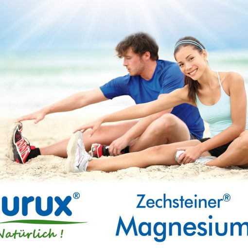 Purux Zechsteiner Magnesium. Zwei junge erwachsene machen Dehn Übungen am Strand